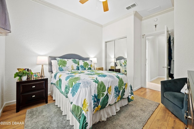 bedroom featuring ceiling fan, ornamental molding, a closet, and light wood-type flooring