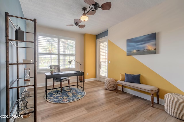 office featuring ceiling fan, a textured ceiling, and light hardwood / wood-style flooring