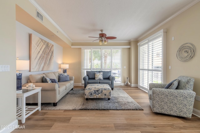 living room with light hardwood / wood-style flooring, ceiling fan, and crown molding