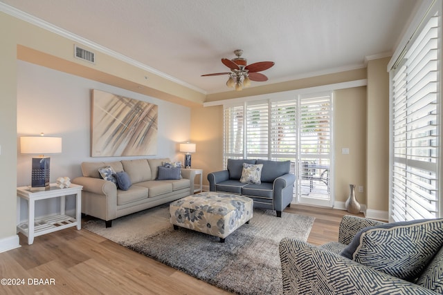 living room with wood-type flooring, ceiling fan, and crown molding