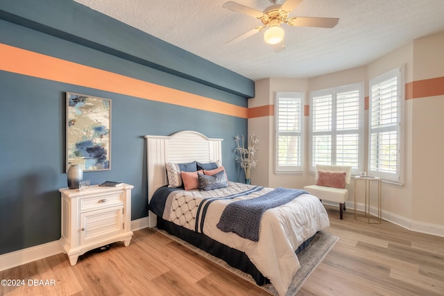 bedroom featuring a textured ceiling, ceiling fan, and light hardwood / wood-style flooring