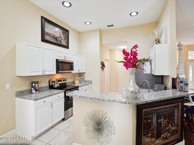 kitchen featuring white cabinetry, kitchen peninsula, appliances with stainless steel finishes, and light stone countertops