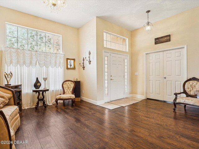 entryway with wood-type flooring and an inviting chandelier