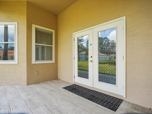 view of exterior entry with a patio and french doors