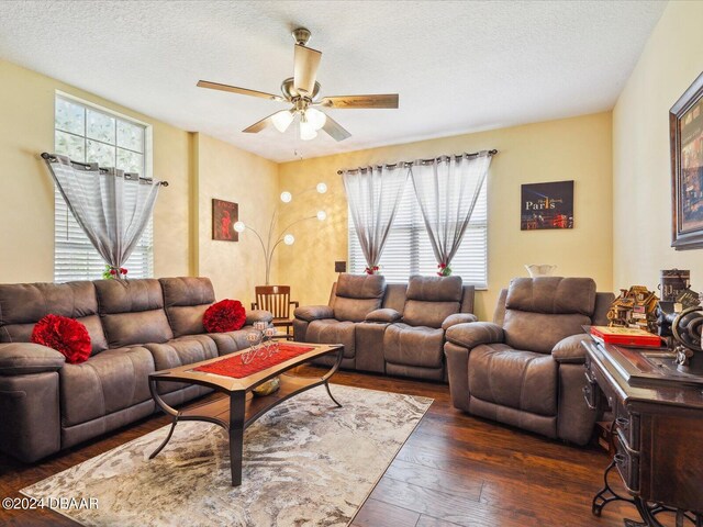 living room featuring a textured ceiling, dark hardwood / wood-style flooring, and ceiling fan