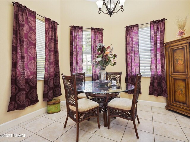 dining area featuring a notable chandelier, light tile patterned floors, and plenty of natural light