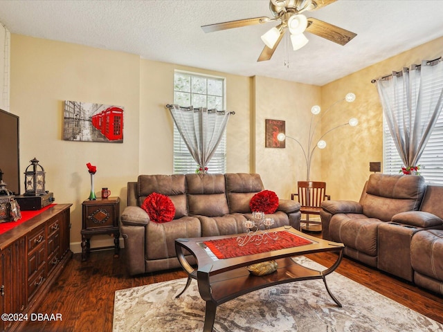 living room featuring a textured ceiling, dark wood-type flooring, and ceiling fan