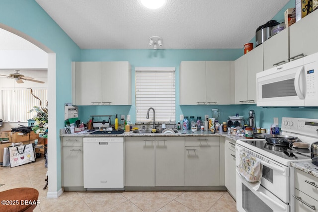 510 Torres Pl, Lady Lake, FL 32159 - kitchen with white appliances, arched walkways, a textured ceiling, ceiling fan, and light stone countertops