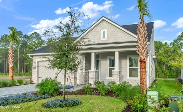 craftsman house featuring a porch, a garage, and a front yard