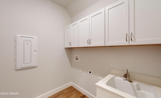 laundry area featuring electric dryer hookup, cabinets, sink, washer hookup, and light hardwood / wood-style floors