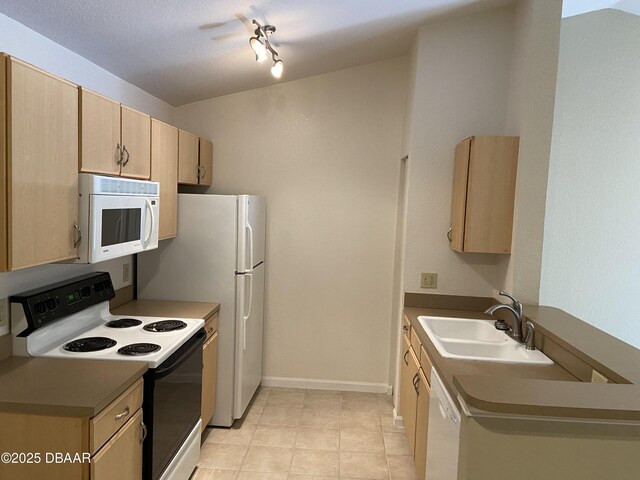 940 Village Trl Unit 2-106, Port Orange, FL 32127 - kitchen featuring white appliances, light brown cabinets, a sink, light tile patterned floors, and baseboards