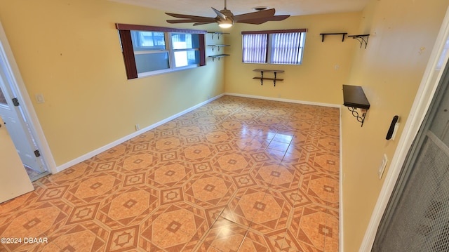 spare room featuring tile patterned floors and ceiling fan