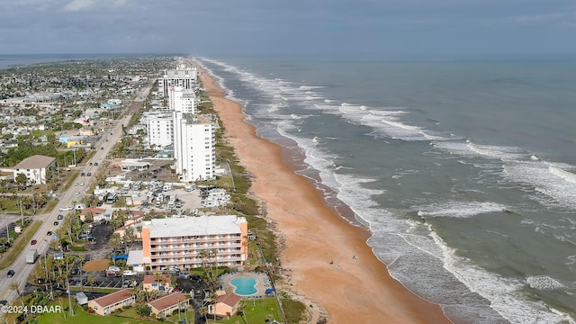 drone / aerial view featuring a beach view and a water view