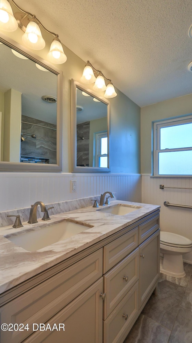 bathroom with vanity, toilet, and a textured ceiling