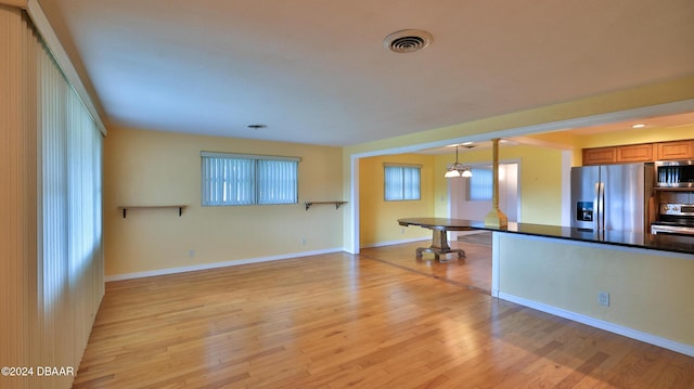 kitchen featuring pendant lighting, light wood-type flooring, appliances with stainless steel finishes, and a chandelier