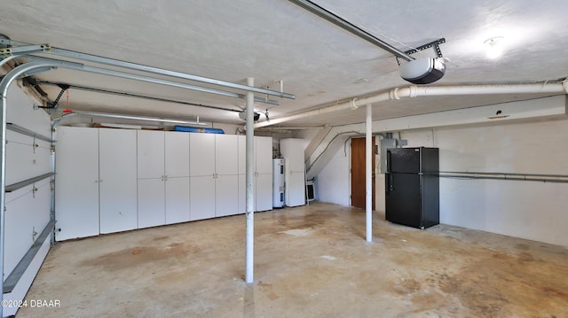 garage featuring a garage door opener, black fridge, and water heater