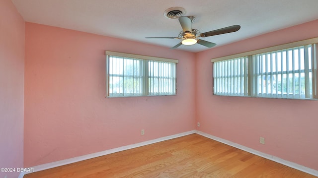 empty room with ceiling fan and light hardwood / wood-style floors