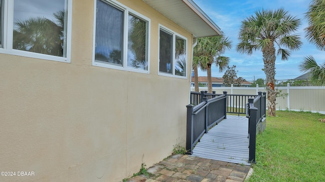 view of property exterior featuring a deck and a yard