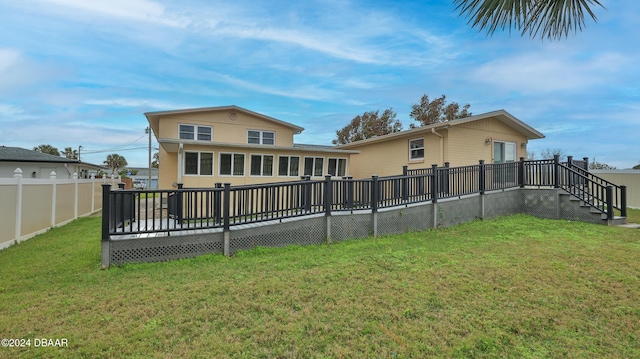 back of property featuring a yard and a wooden deck