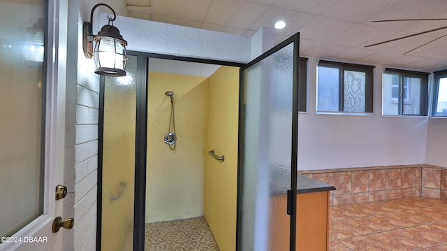 interior space featuring a shower, a paneled ceiling, and tile patterned floors