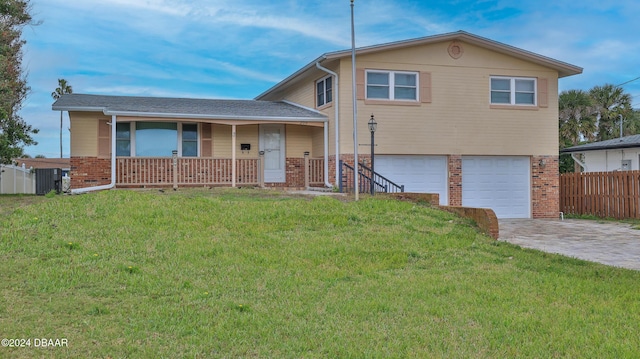 split level home featuring a front lawn, a porch, and a garage