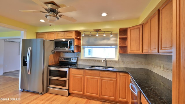 kitchen featuring decorative backsplash, appliances with stainless steel finishes, light wood-type flooring, and sink