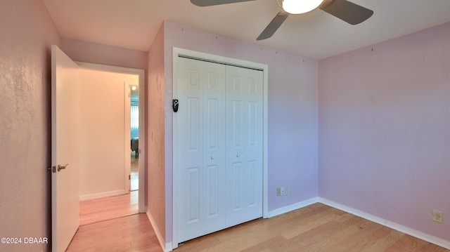 unfurnished bedroom featuring ceiling fan, light hardwood / wood-style flooring, and a closet