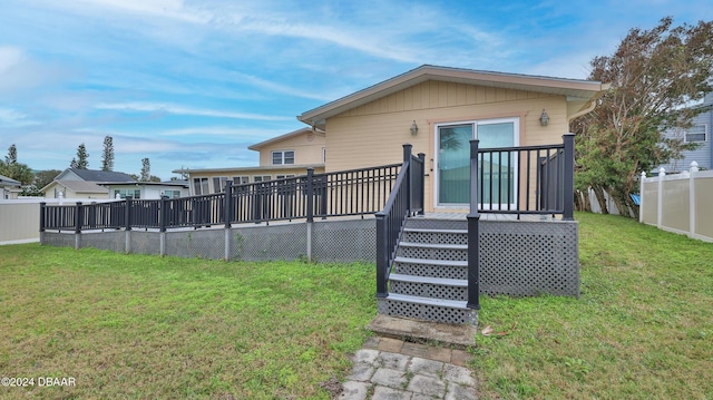 back of property featuring a yard and a deck