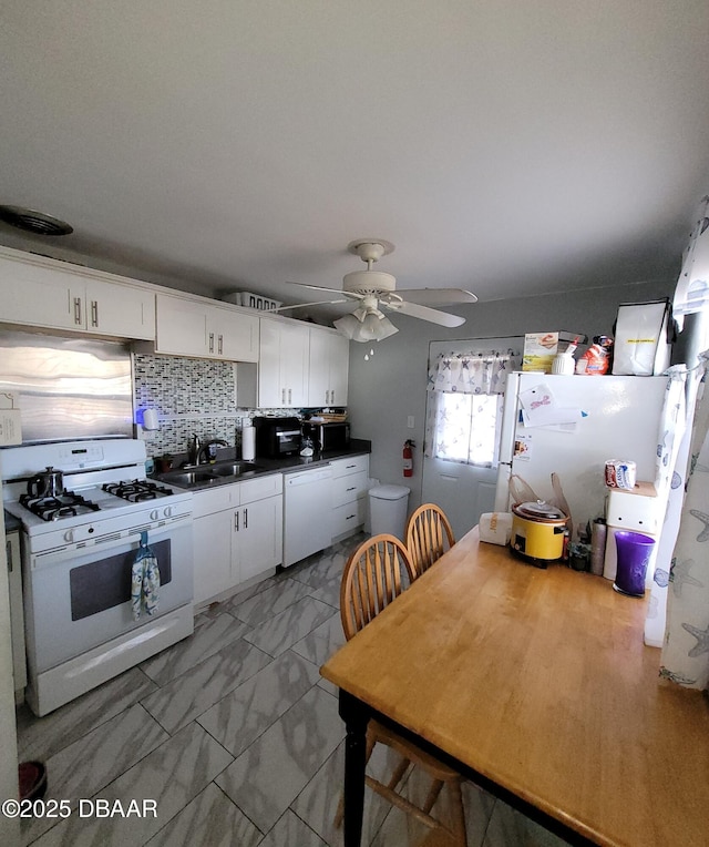 kitchen with white appliances, sink, ceiling fan, white cabinets, and tasteful backsplash