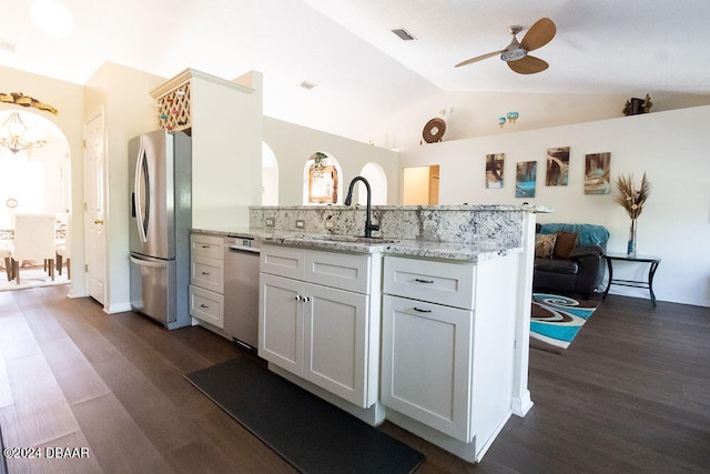 kitchen with stainless steel appliances, sink, vaulted ceiling, white cabinets, and kitchen peninsula