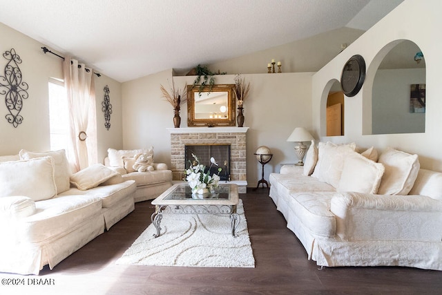 living room with a stone fireplace, dark hardwood / wood-style floors, and vaulted ceiling