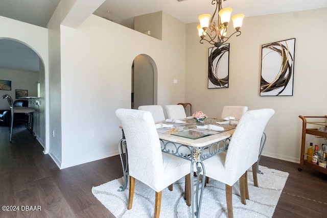 dining area with dark wood-type flooring and a chandelier