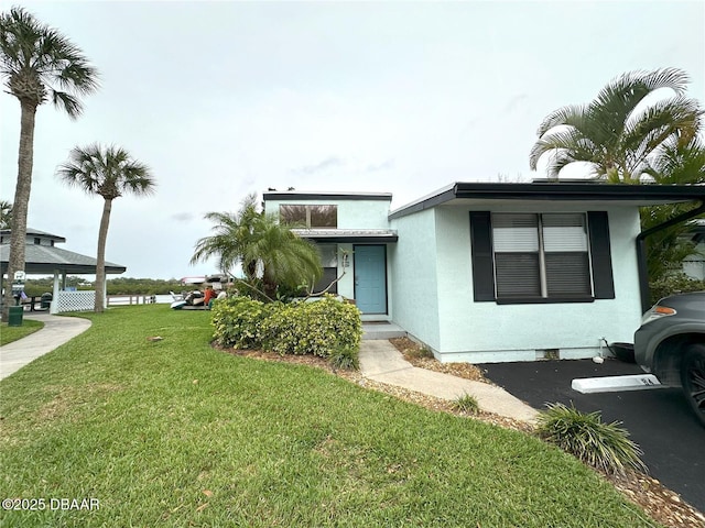 84 Heather Point Ct, New Smyrna Beach, FL 32169 - view of front of property with a front yard and stucco siding