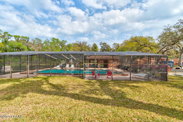 view of swimming pool with a lawn, glass enclosure, and a patio