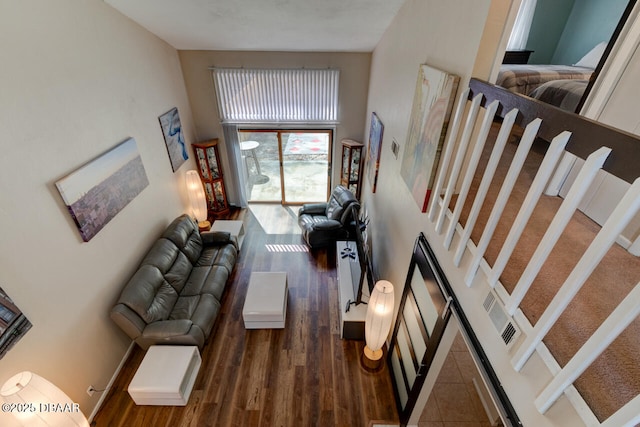 living area featuring wood finished floors and a high ceiling