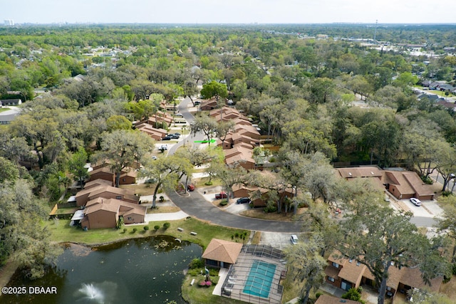aerial view of property's location featuring nearby suburban area, a large body of water, and a forest