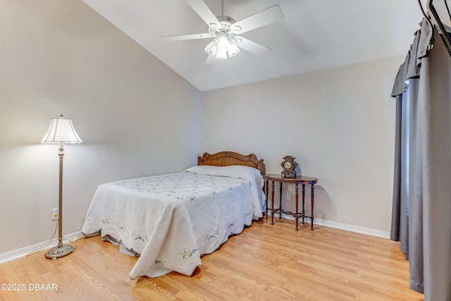 bedroom with vaulted ceiling, wood finished floors, baseboards, and ceiling fan