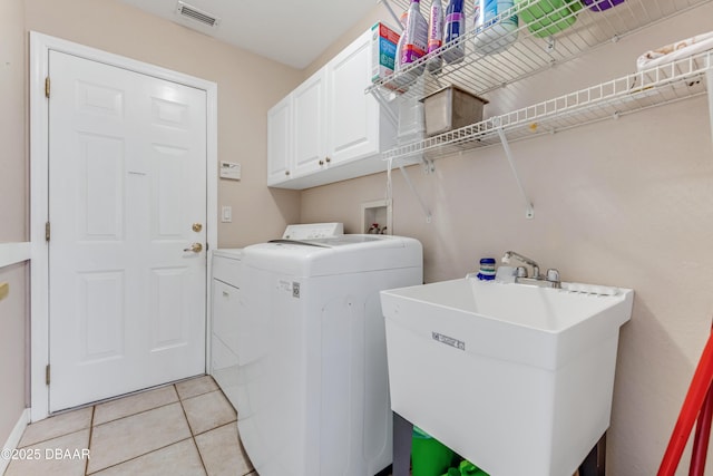 washroom featuring visible vents, light tile patterned flooring, cabinet space, separate washer and dryer, and a sink