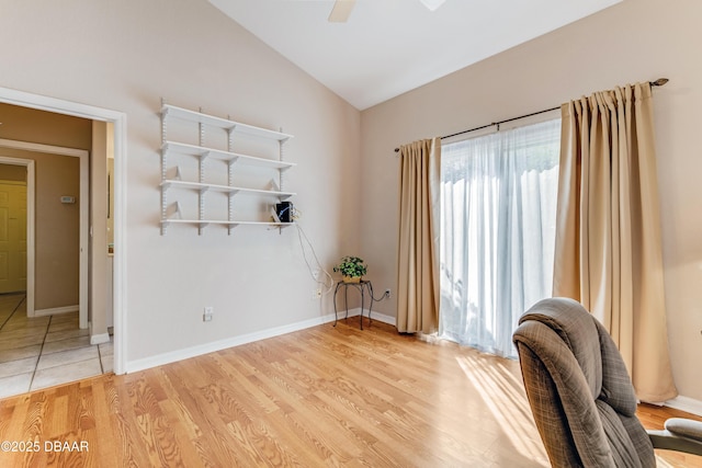 unfurnished office featuring baseboards, light wood-style flooring, a ceiling fan, and vaulted ceiling