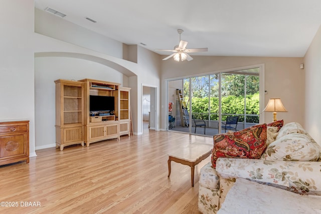 living room with ceiling fan, visible vents, lofted ceiling, and wood finished floors