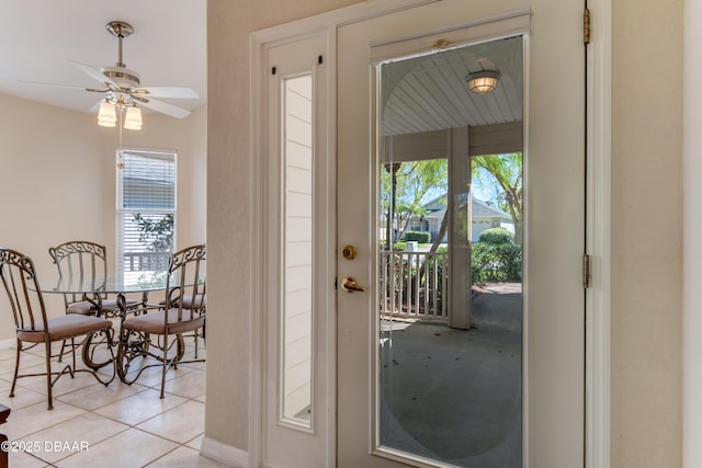 doorway to outside featuring ceiling fan and tile patterned flooring