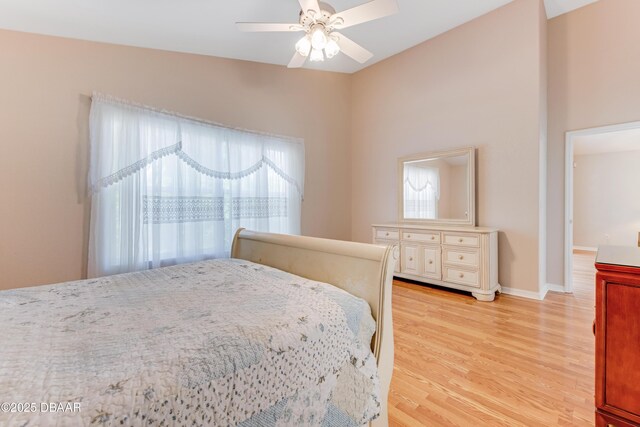 bedroom with baseboards, light wood-style floors, and a ceiling fan