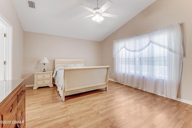 bedroom featuring lofted ceiling, light wood-style floors, visible vents, and ceiling fan