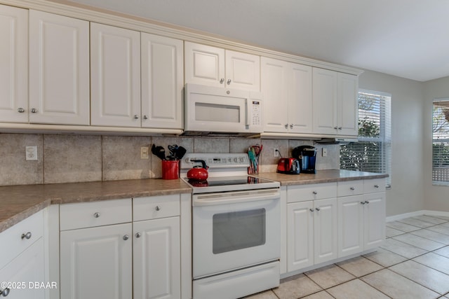 kitchen featuring white appliances, light tile patterned floors, baseboards, white cabinets, and backsplash