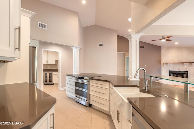 kitchen featuring appliances with stainless steel finishes, ceiling fan, vaulted ceiling, and ornate columns