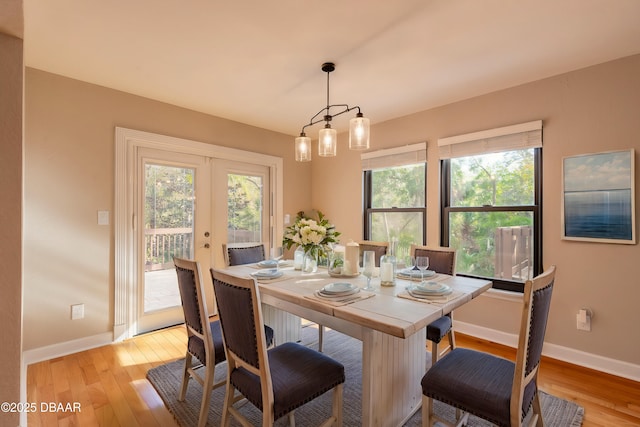 dining space with light wood-type flooring and french doors