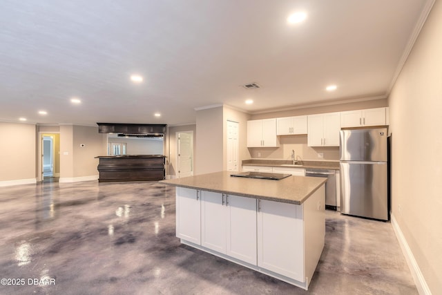 kitchen featuring appliances with stainless steel finishes, stone counters, a kitchen island, sink, and white cabinetry