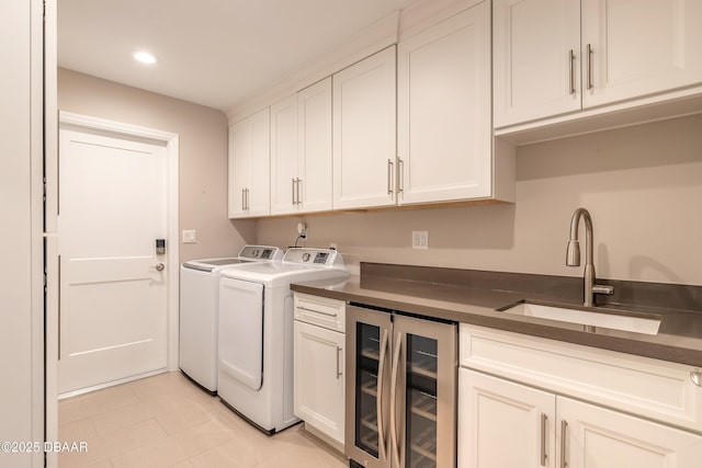 laundry room featuring cabinets, separate washer and dryer, sink, light tile patterned floors, and beverage cooler