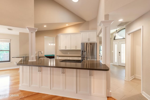 kitchen featuring light hardwood / wood-style flooring, sink, decorative columns, stainless steel fridge, and white cabinets