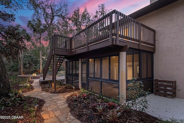 back house at dusk with a sunroom